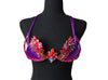 Carnival Orchid Flame Decorated Wire Bra with deep purple fabric, vibrant red and gold floral gem embellishments, and sparkling center crystals, displayed on a black mannequin—perfect for carnival, festivals, and stand-out performances. #CarnivalMW #CarnivalReady #FestivalFashion #WireBra
