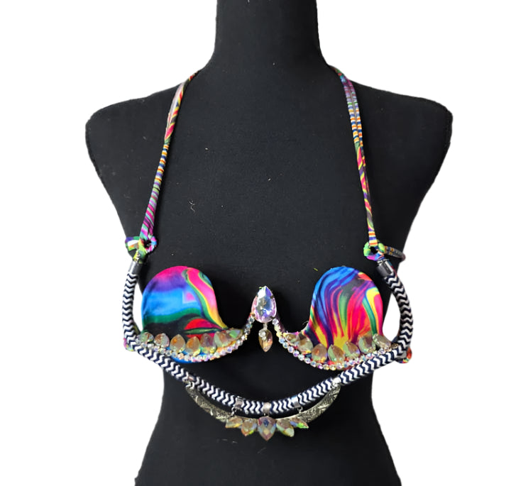 Psychedelic Prism Dream Decorated Wire Bra with swirling multicolor rainbow cups, black and white zigzag trim, and sparkling iridescent gems, displayed on a black mannequin—ideal for festivals, carnivals, and performance wear. #CarnivalMW #CarnivalReady #WireBra