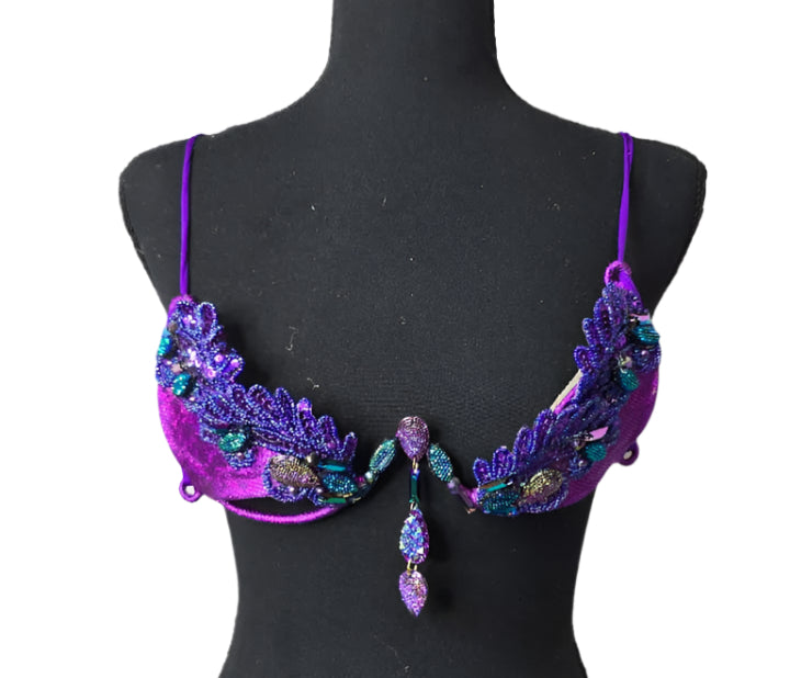 Twilight Siren Decorated Wire Bra featuring a deep purple wire base, shimmering blue and teal gem accents, and intricate sequin details, displayed on a black mannequin—perfect for carnivals, samba dancers, and festival performances. #CarnivalMW #CarnivalReady #FestivalFashion #WireBra #TwilightSiren #ShowgirlStyle #CustomCostumes #carnivalfeathers #carnivalcostume #carnivalbackpack #festival #festivalwear #festivallooks #carnival #mondaywear