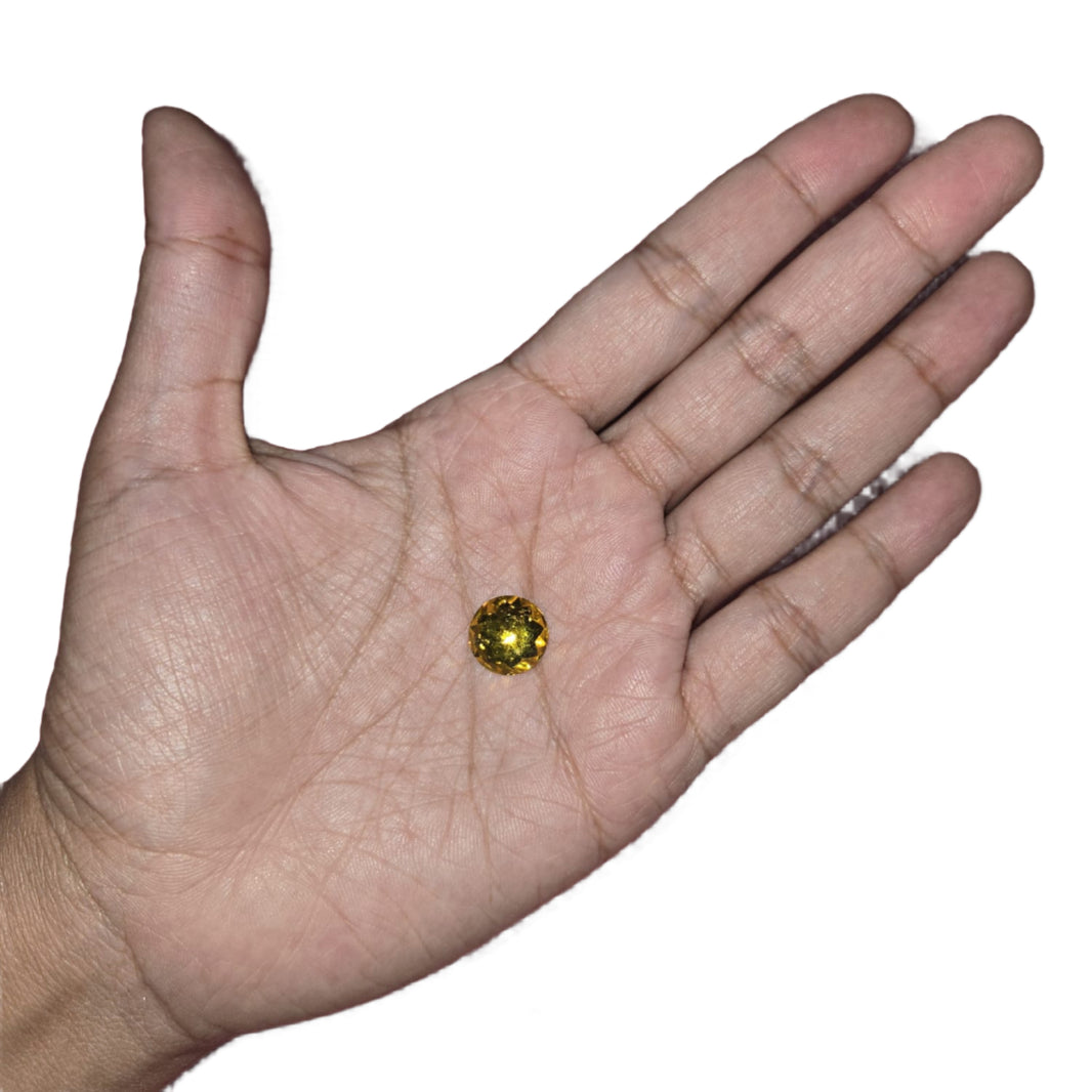 Close-up of a 10mm yellow round flatback rhinestone with a star pattern, perfect for adding a bright and unique touch to carnival costumes and custom designs