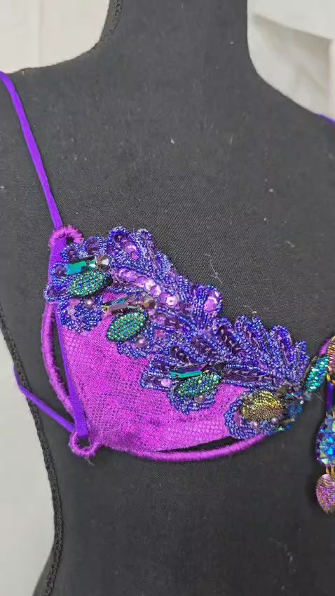 Twilight Siren Decorated Wire Bra featuring a deep purple wire base, shimmering blue and teal gem accents, and intricate sequin details, displayed on a black mannequin—perfect for carnivals, samba dancers, and festival performances. #CarnivalMW #CarnivalReady #FestivalFashion #WireBra #TwilightSiren #ShowgirlStyle #CustomCostumes #carnivalfeathers #carnivalcostume #carnivalbackpack #festival #festivalwear #festivallooks #carnival #mondaywear