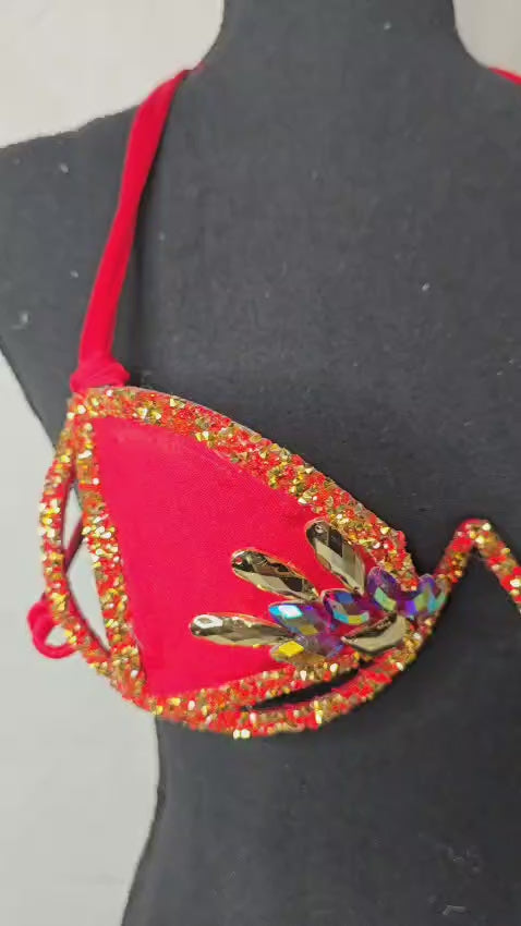 Video of Red flame crystal decorated wire bra with gold rhinestone trim on a black mannequin, front view. #carnivalmw #festival #festivalwear #festivallooks #wirebra #carnivalcostumes