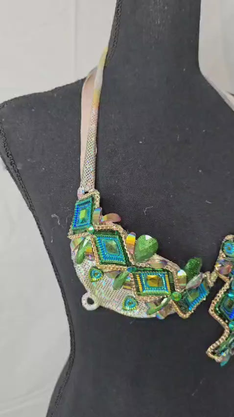 Jade Carnival Decorated Wire Bra featuring a shimmering iridescent base, bold emerald green and blue geometric gem patterns, and gold accents, displayed on a black mannequin—perfect for carnivals, samba dancers, and festival performances. #CarnivalMW #CarnivalReady #FestivalFashion #WireBra #JadeCarnival #ShowgirlStyle #CustomCostumes #carnivalfeathers #carnivalcostume #carnivalbackpack #festival #festivalwear #festivallooks #carnival #mondaywea