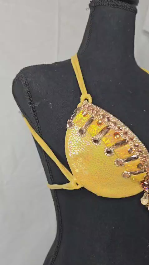 Sun Goddess Decorated Wire Bra featuring a vibrant yellow wire base, radiant gold and amber gem embellishments, and intricate chain accents, displayed on a black mannequin—perfect for carnivals, samba dancers, and festival performances. #CarnivalMW #CarnivalReady #FestivalFashion #WireBra #SunGoddess #ShowgirlStyle #CustomCostumes #carnivalfeathers #carnivalcostume #carnivalbackpack #festival #festivalwear #festivallooks #carnival #mondaywear